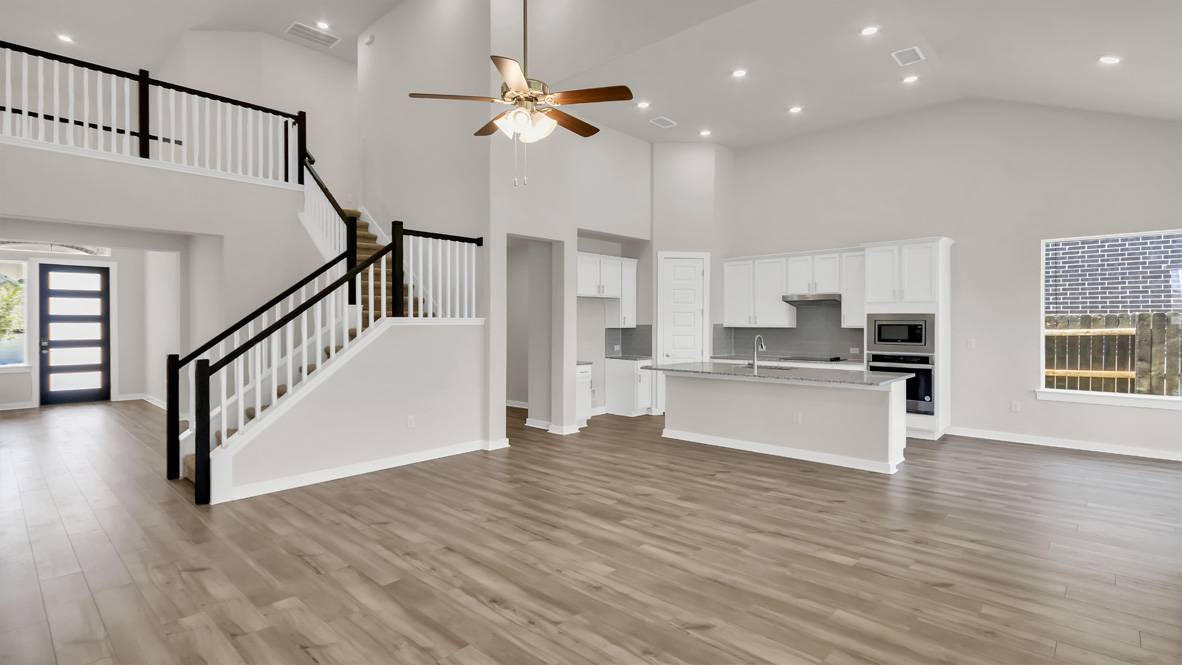 Kitchen island in D.R. Horton layout connects dining, main living areas, with stairs adding efficient flow