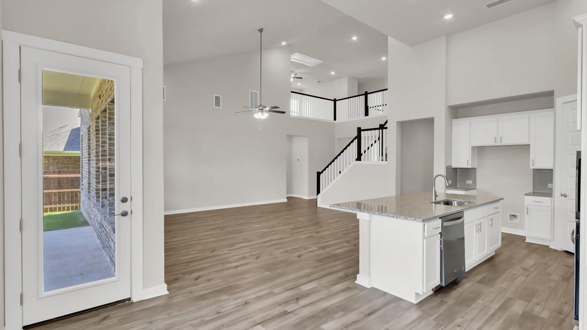 Spacious living room with view into dining and kitchen areas, and outside access at Rosenbusch Ranch
