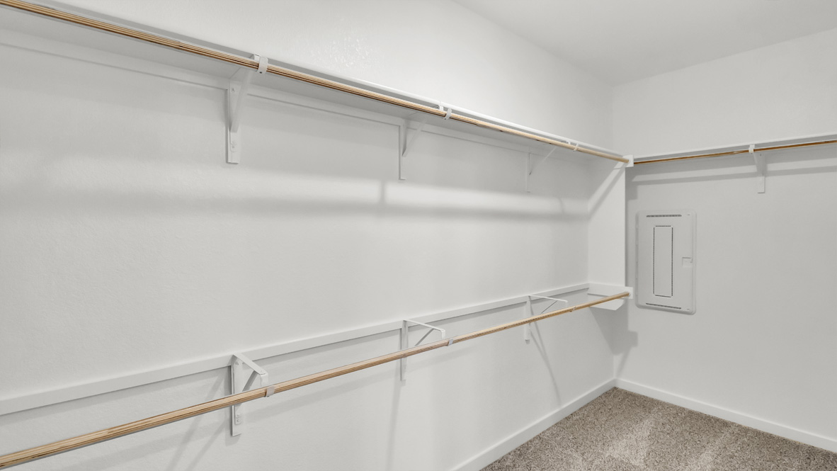 Interior view of walk-in closet in the primary bedroom and spa-inspired ensuite in Rosenbusch Ranch  new home by D.R. Horton