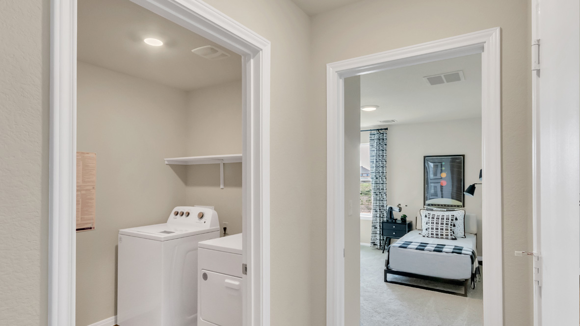 Rosenbusch Ranch utility laundry room with overhead shelving, drop zone, folding area near garage crafted by D.R. Horton