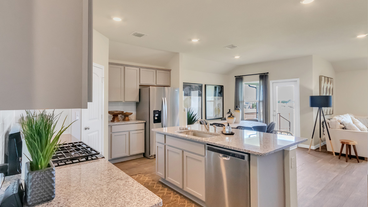 Functional kitchen island adds a sink, multi-prep zones, cabintes and a pantry, new appliance suite, and outside access