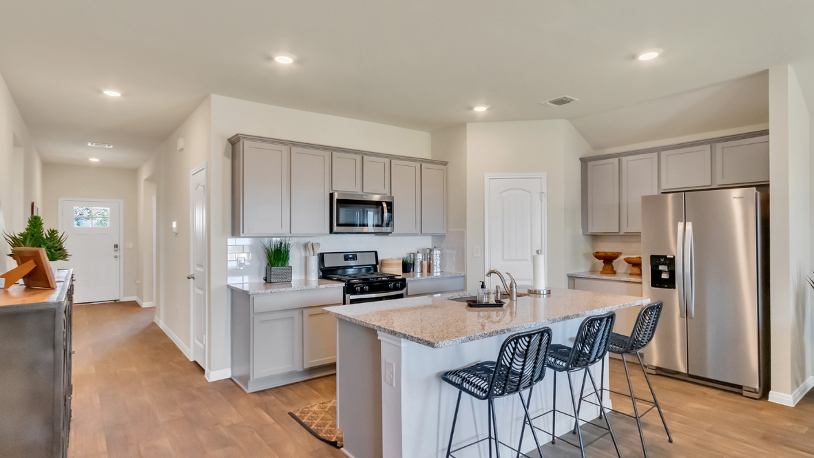 Central kitchen island anchors the home adding a dining option, full sink, pantry and storage, multi-prep zones