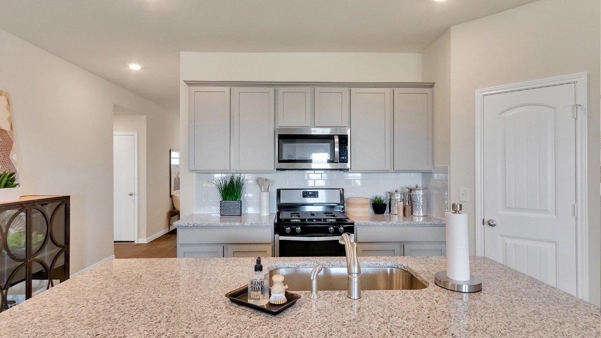 Central kitchen island adds a sink, seating, designed to anchor the home, pantry, prep zones, perfect for entertaining, everyday life