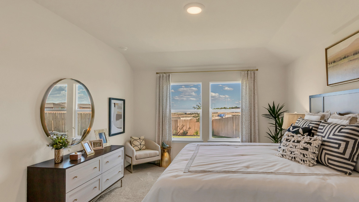 Primary bedroom features ample space, double windows, soft carpet, a stylish walk-in closet, and a private ensuite bath