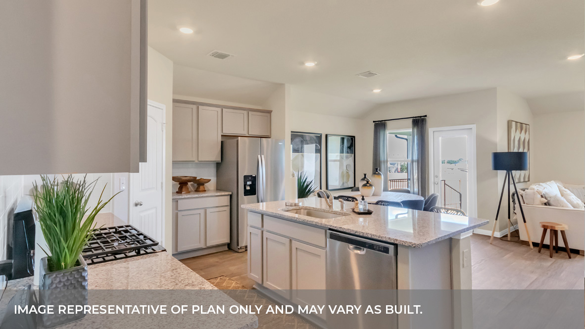 Kitchen area with white granite countertops, large island, light gray cabinets, and stainless steel appliances with pantry in the corner.