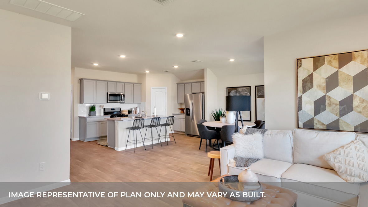 A spacious open floor plan living room, kitchen, and dining area, hardwood floors, and trey ceilings.