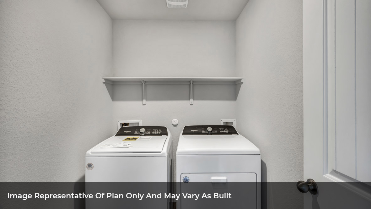 Spacious laundry area has room for a washer and dryer with built in shelves.