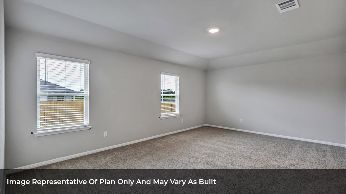 Primary bedroom with carpeted floors, two large windows, and trey ceilings.