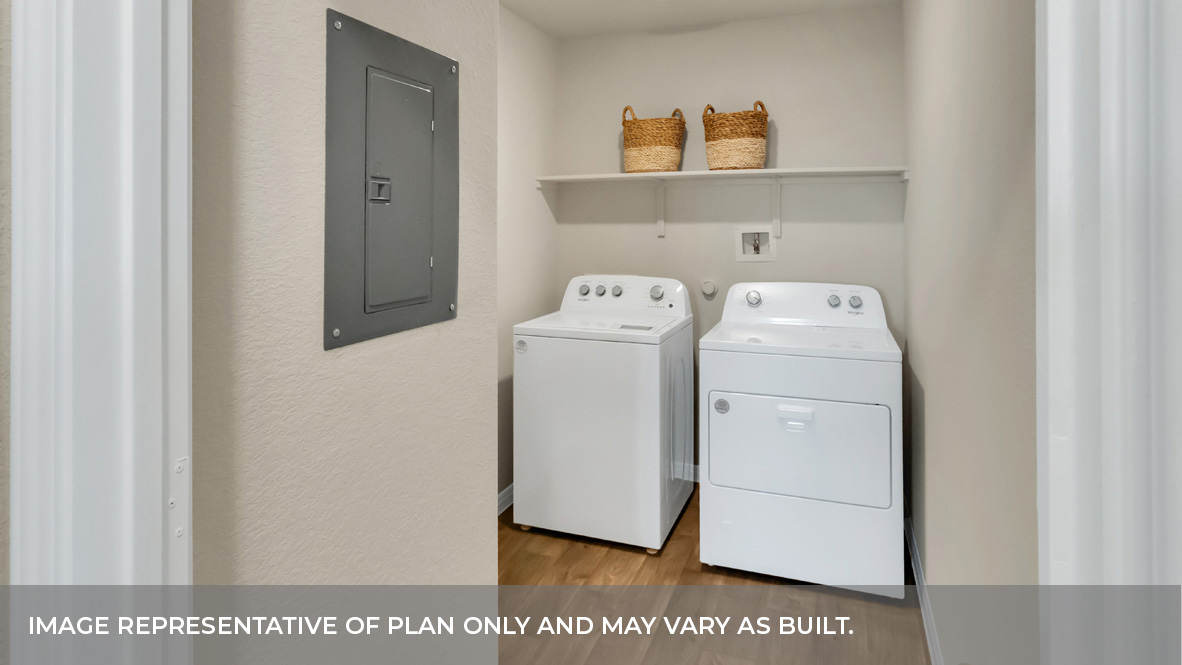 Spacious laundry area has room for a washer and dryer with built in shelves.
