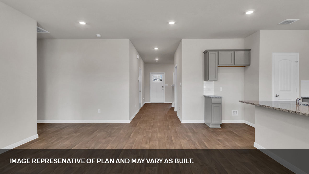 Living area with view of the front entrance and kitchen area to the right.