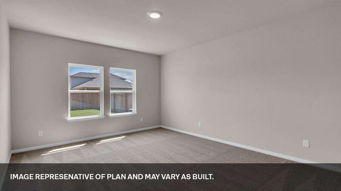 Primary bedroom with carpeted floors, two large windows, and trey ceilings.