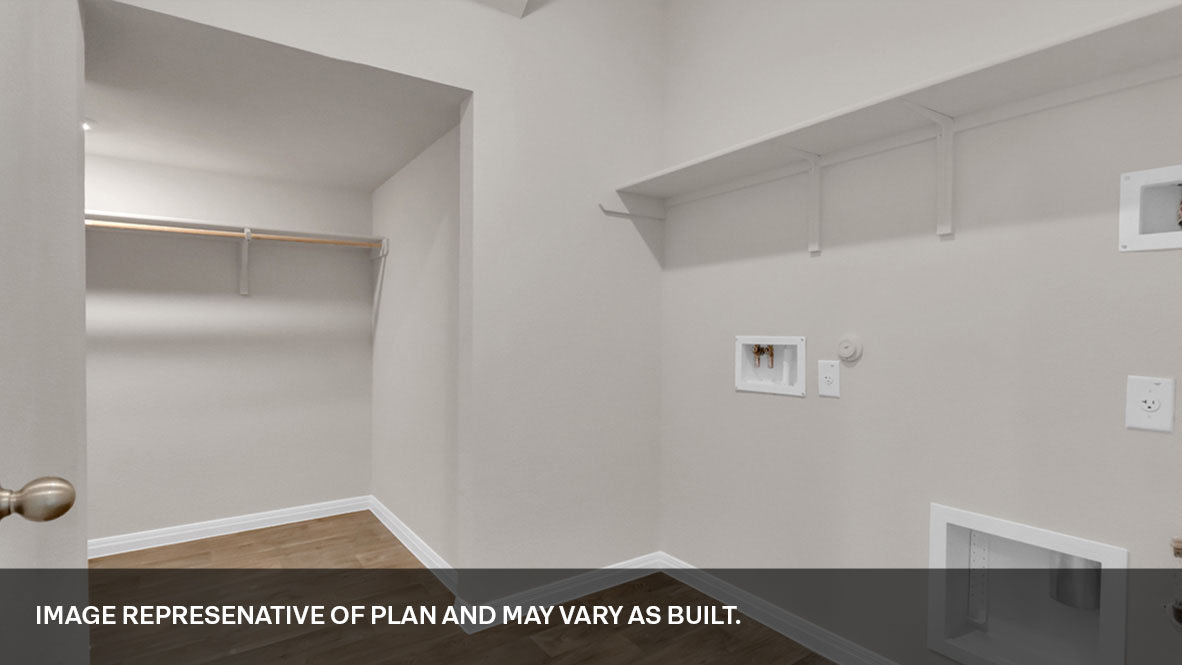 Spacious laundry area has room for a washer and dryer with built in shelves with closet for extra storage.