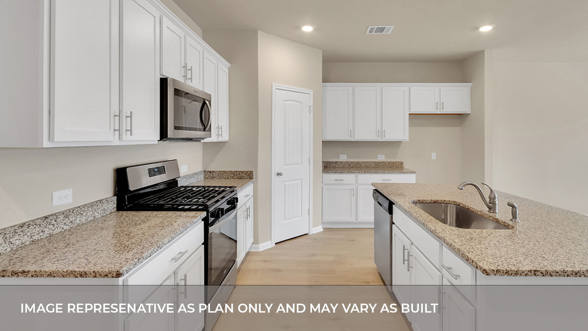Side view of the kitchen area with tan granite countertops, large island, whte cabinets, and stainless steel appliances with pantry in the corner.