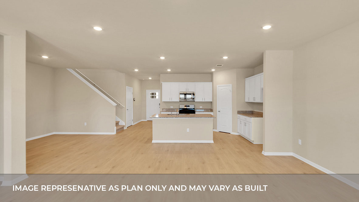 Living area with kitchen and stairs in the back.