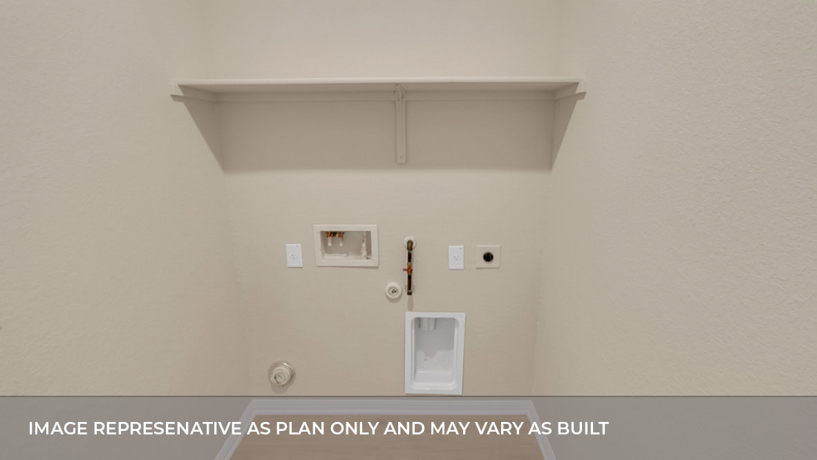 Spacious laundry area has room for a washer and dryer with built in shelves.