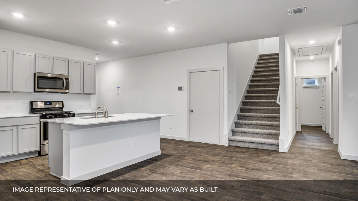 Kitchen area with stairs and front entry foyer.