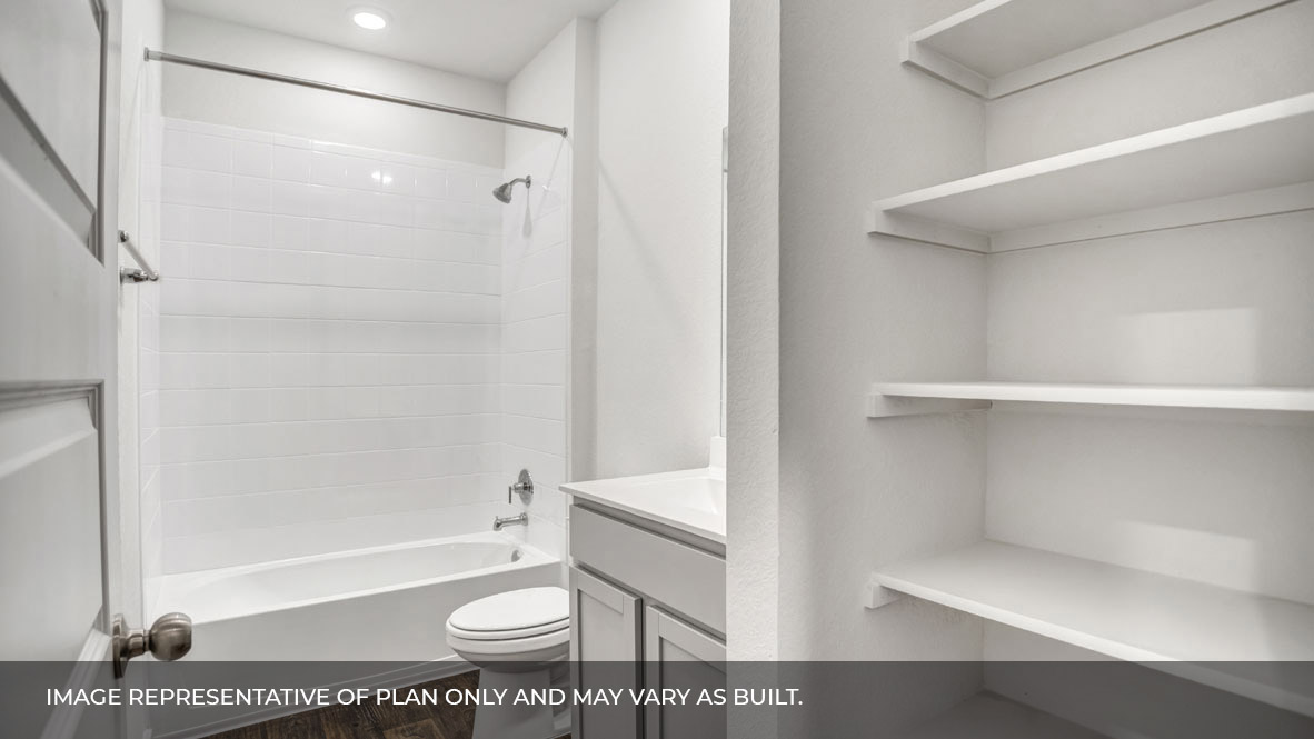 Bathroom with white single sink vanity, with shower and tub combination and built in shelving.