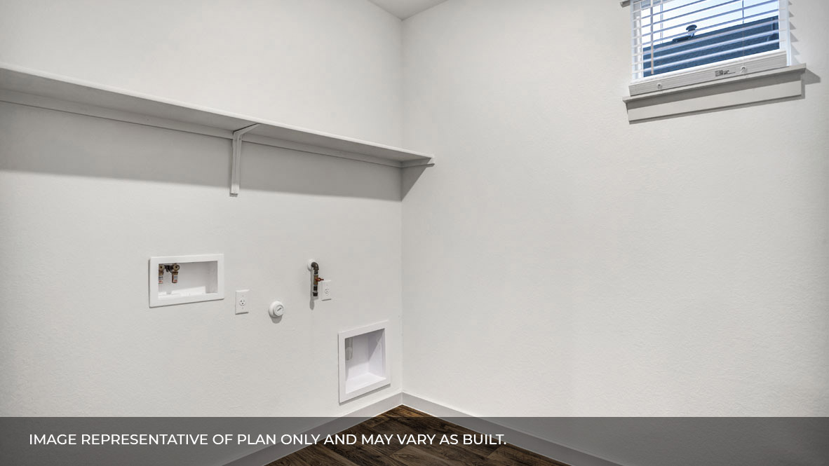 Spacious laundry area has room for a washer and dryer with built in shelves.