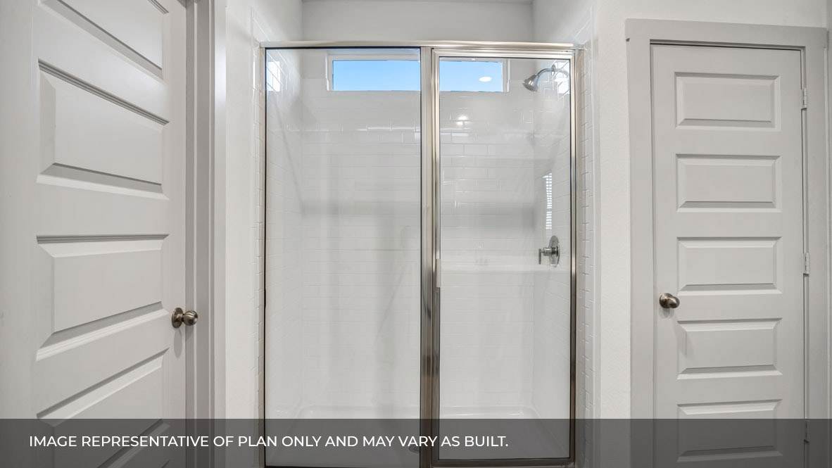 Primary bathroom with white tile walk-in shower, bright light fixtures, and with built in shelves.
