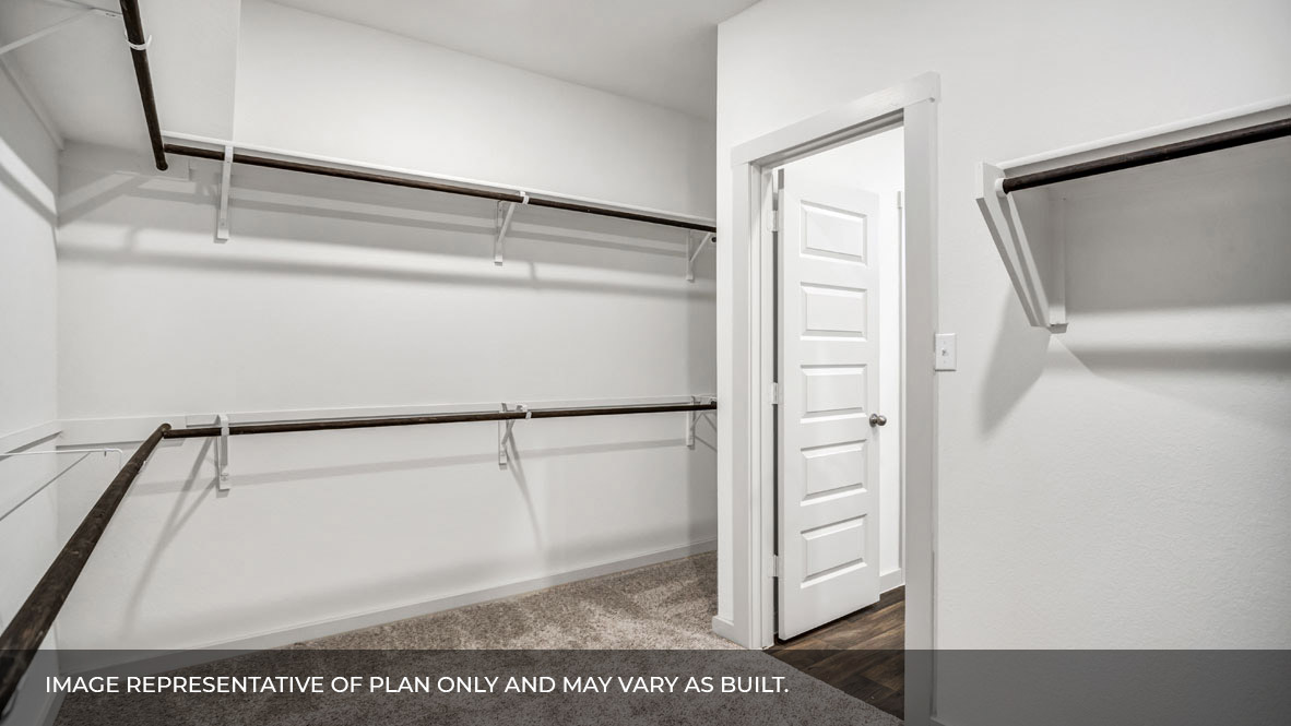 Spacious walk in closet with built in shelving in the primary bathroom.