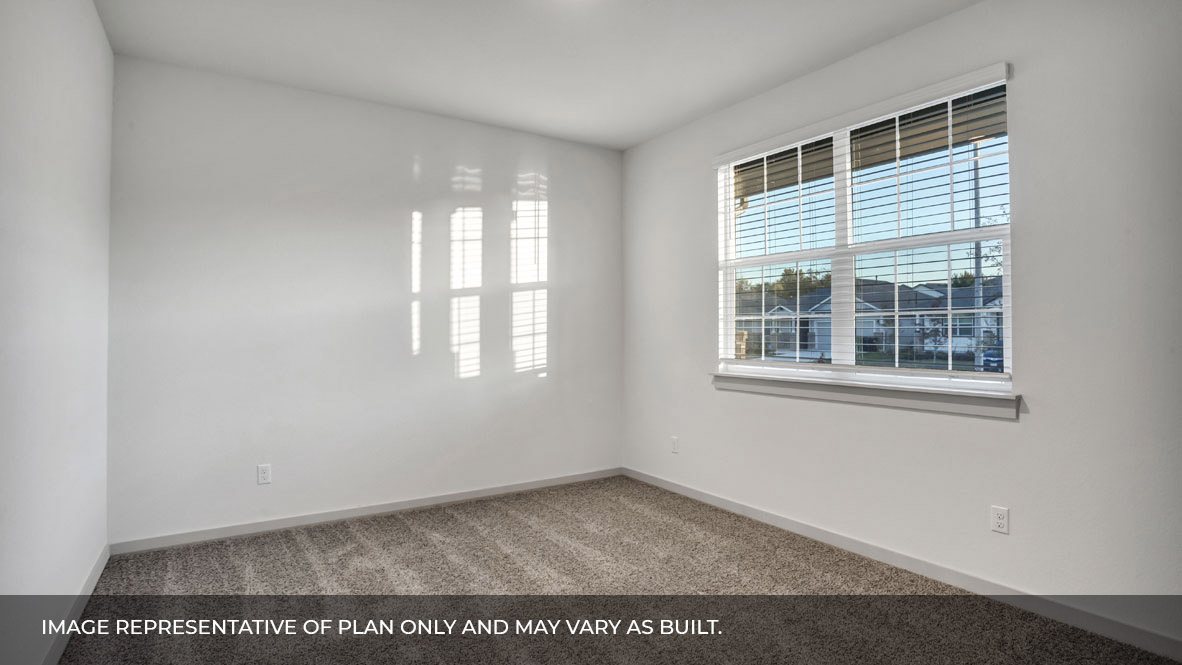 Bedroom with carpeted floors and large double windows for natural light.