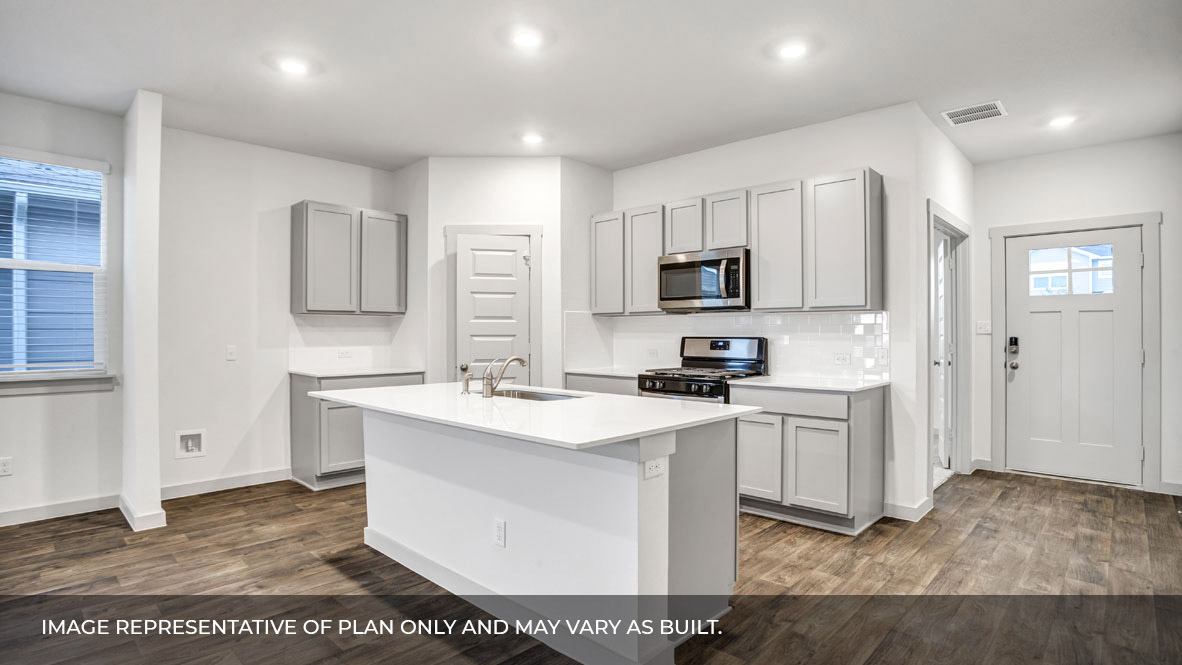Kitchen area with white granite countertops, large island, white cabinets, and stainless steel appliances with pantry in the corner.