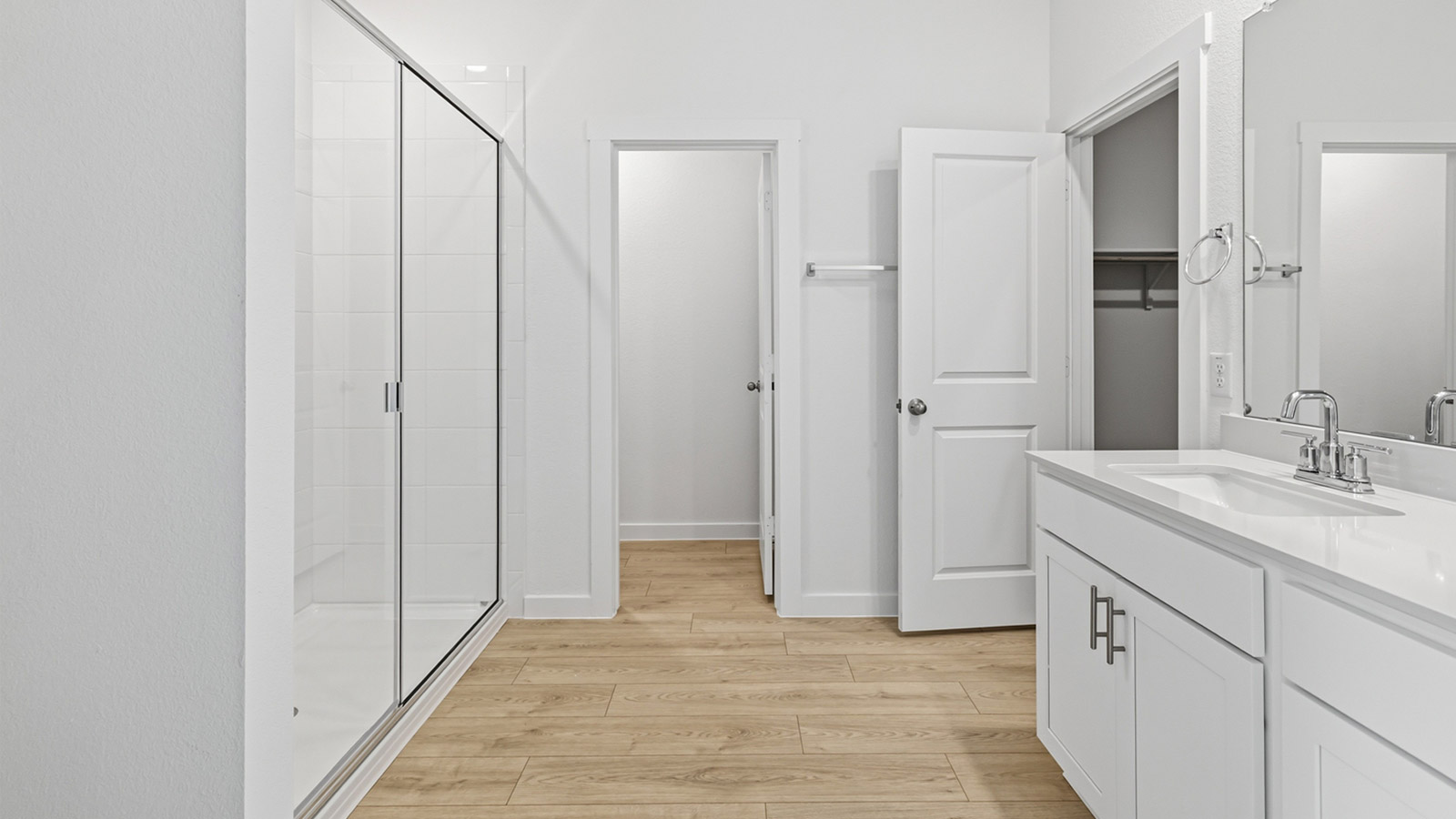 Luxurious main bathroom with quartz vanity and walk-in shower.