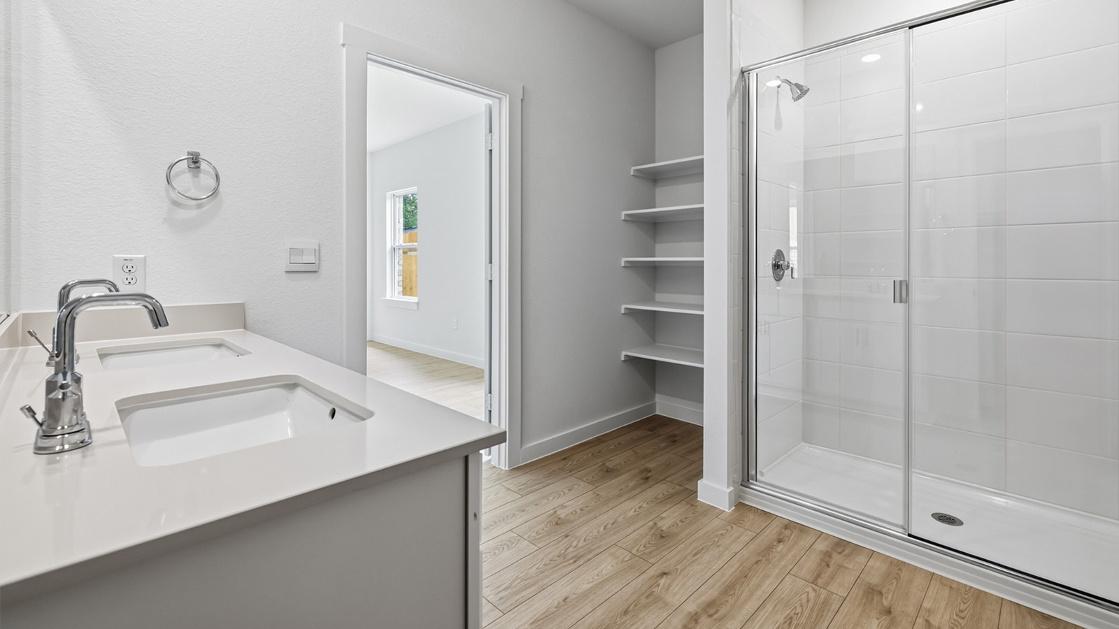 Dual vanity sink and walk-in shower in primary bathroom.