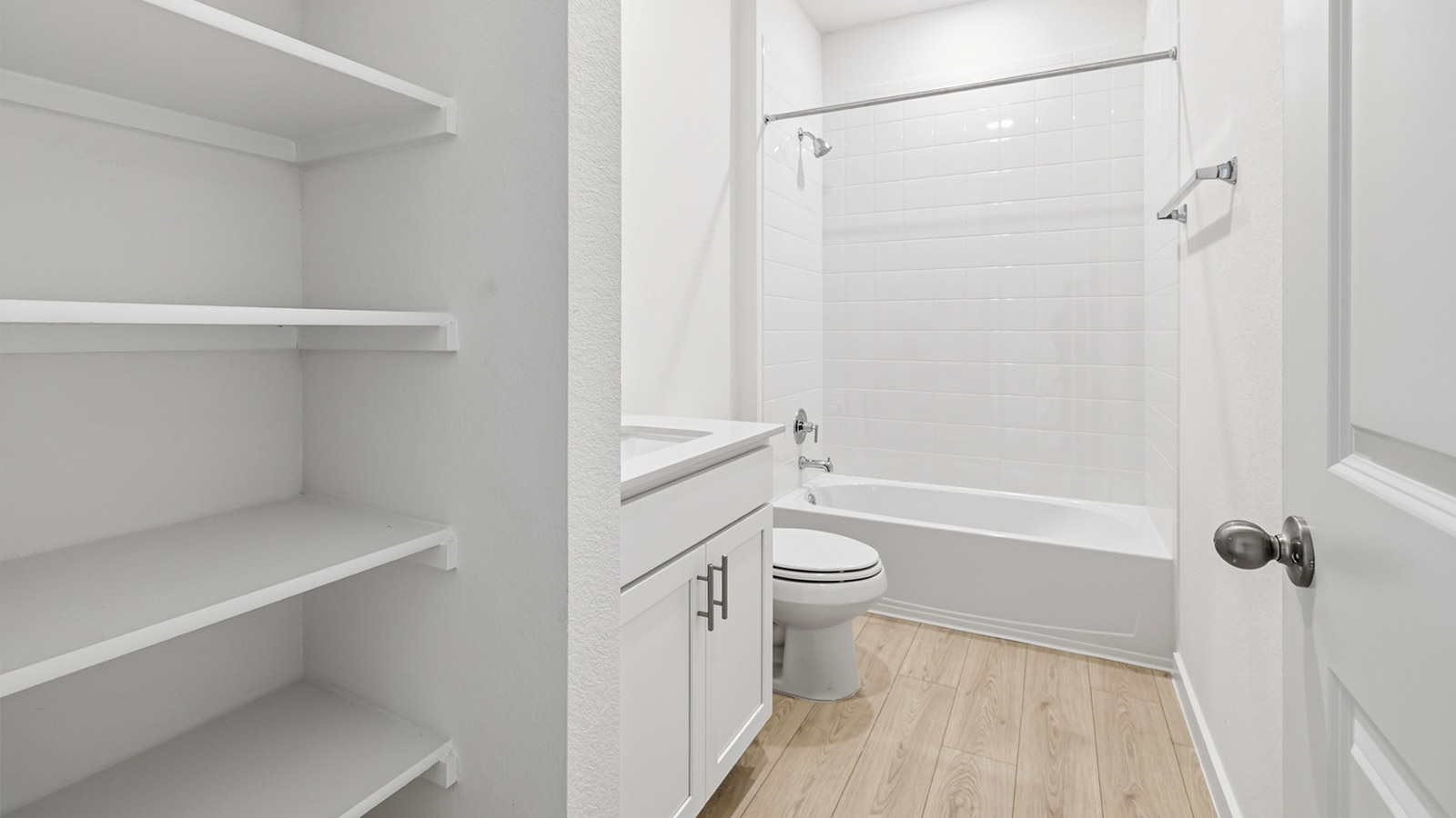 Secondary bathroom with storage shelves.