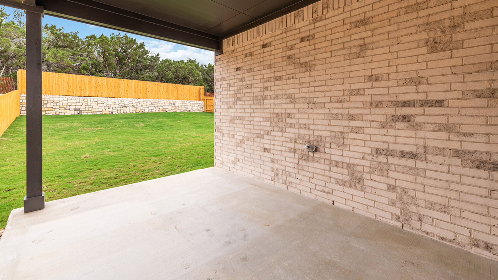 Covered back patio and view of backyard.