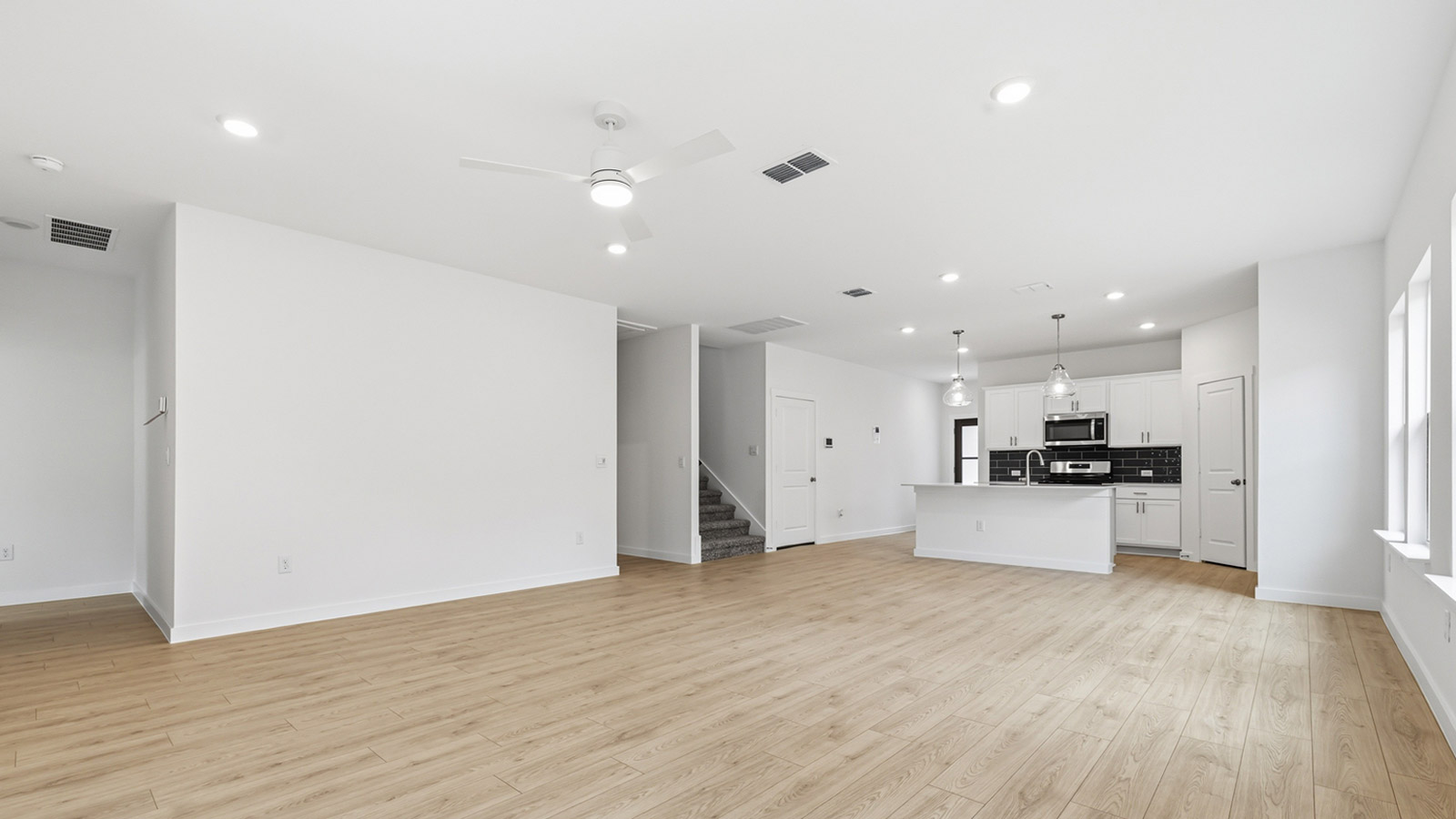 Open living area with premium wood plank flooring.