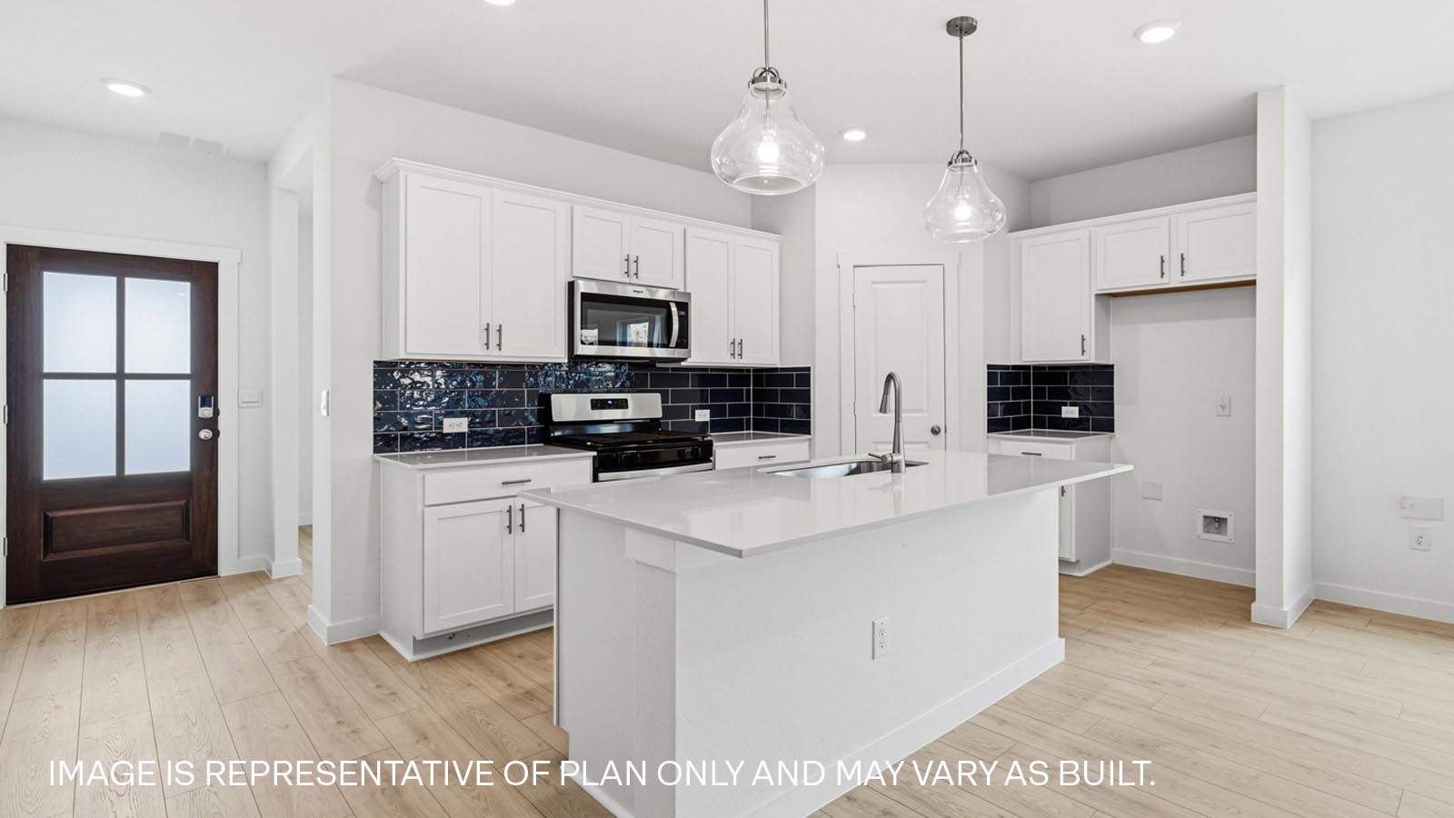 Beautiful kitchen with tile backsplash, pendant lights, and cabinets with hardware.