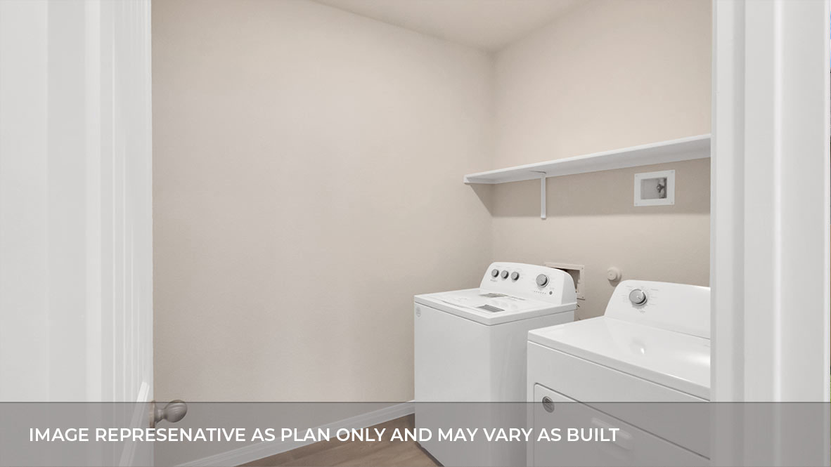 Spacious laundry area has room for a washer and dryer with built in shelves.