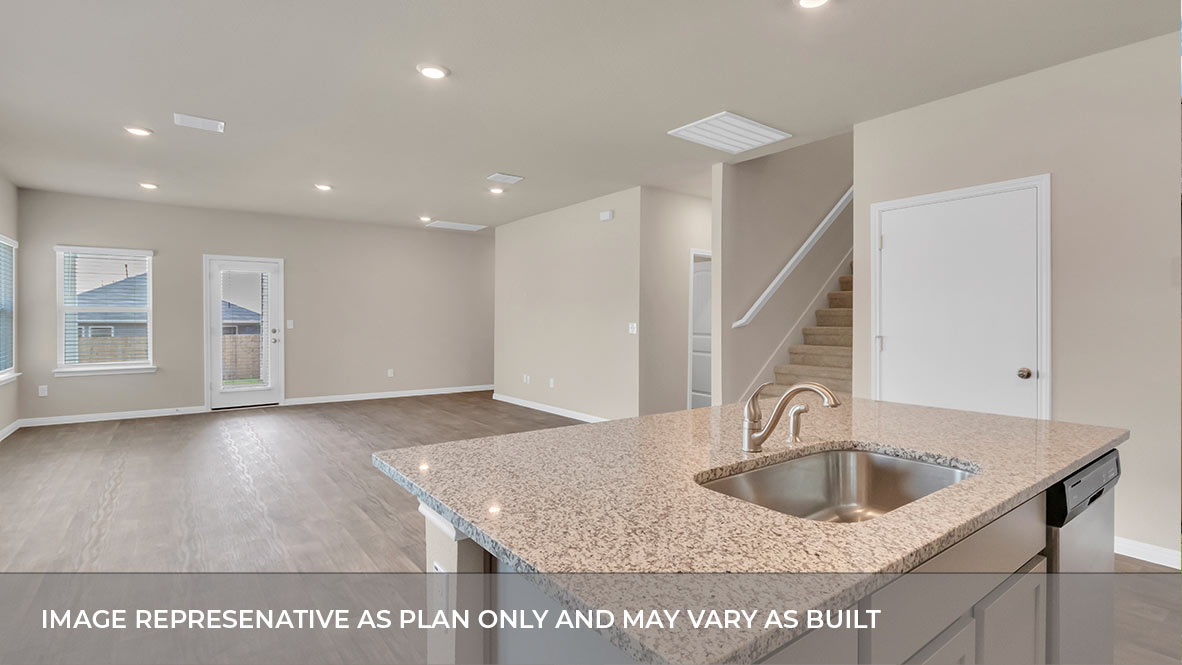 Open concept kitchen with large island with view of the living and and dining area and stairs.