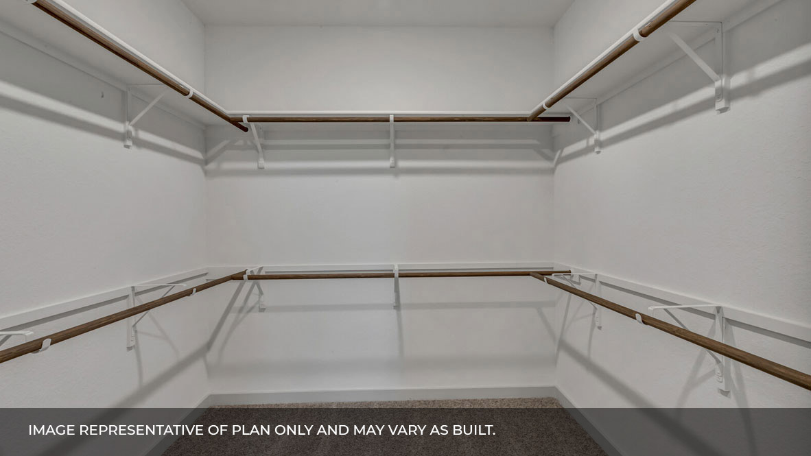 Spacious walk in closet with built in shelving in the primary bathroom.