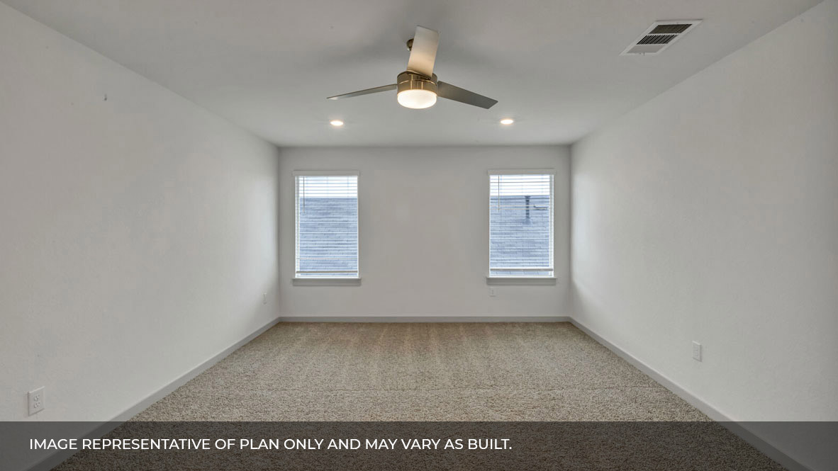 Spacious primary bedroom with carpeted floors, two large windows, and trey ceilings.
