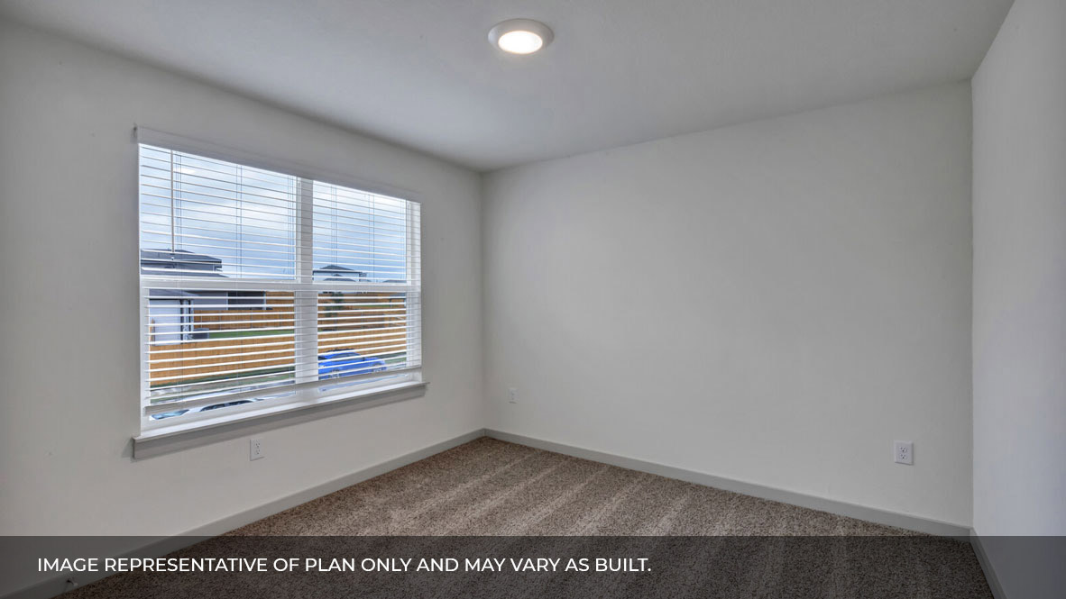 Bedroom with carpeted floors and large double window for natural light.