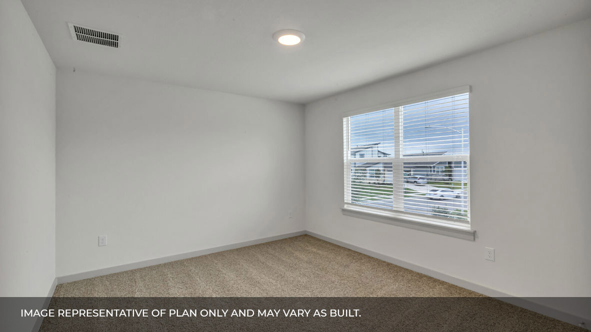 Bedroom with carpeted floors and large double window for natural light.