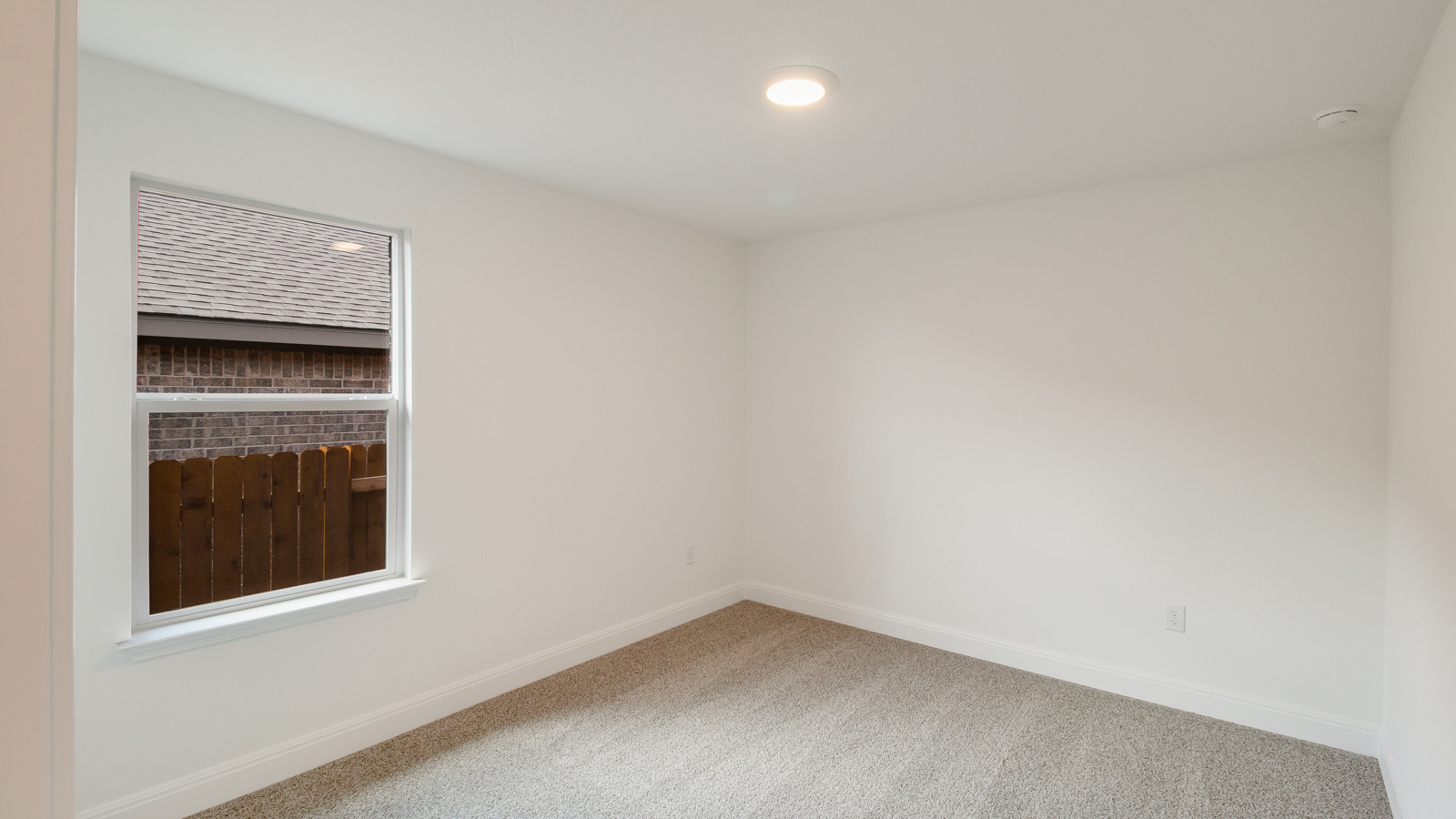 bedroom with beige carpet, white walls and a window