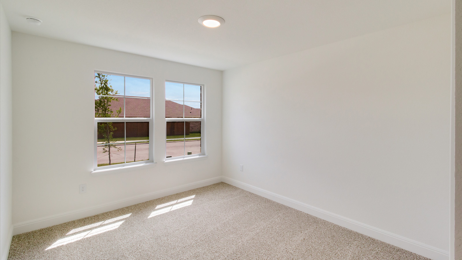 bedroom with beige carpet, white walls and a window