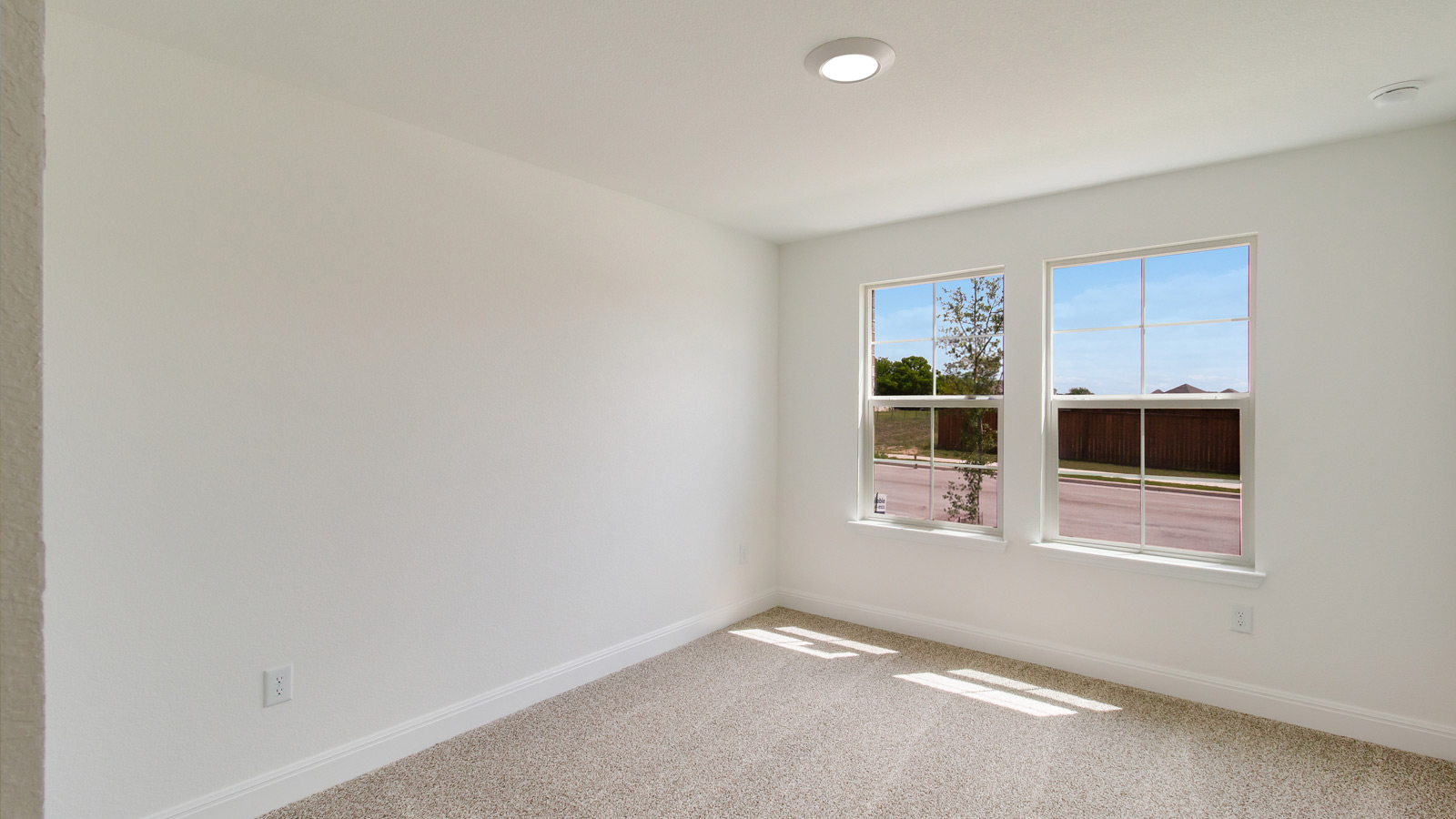 bedroom with beige carpet, white walls and a window
