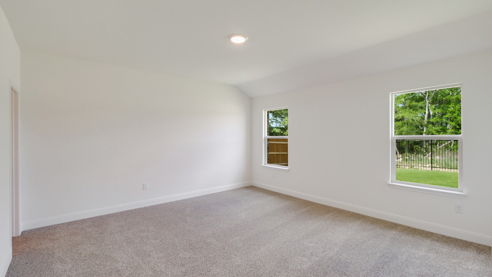 bedroom with beige carpet, white walls and 2 windows