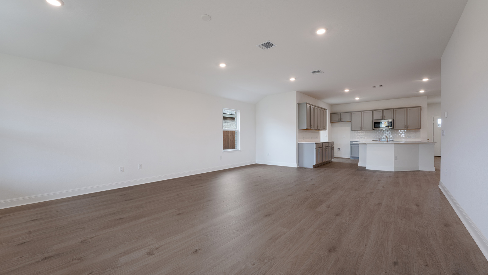 Vast living area with laminated wood flooring.