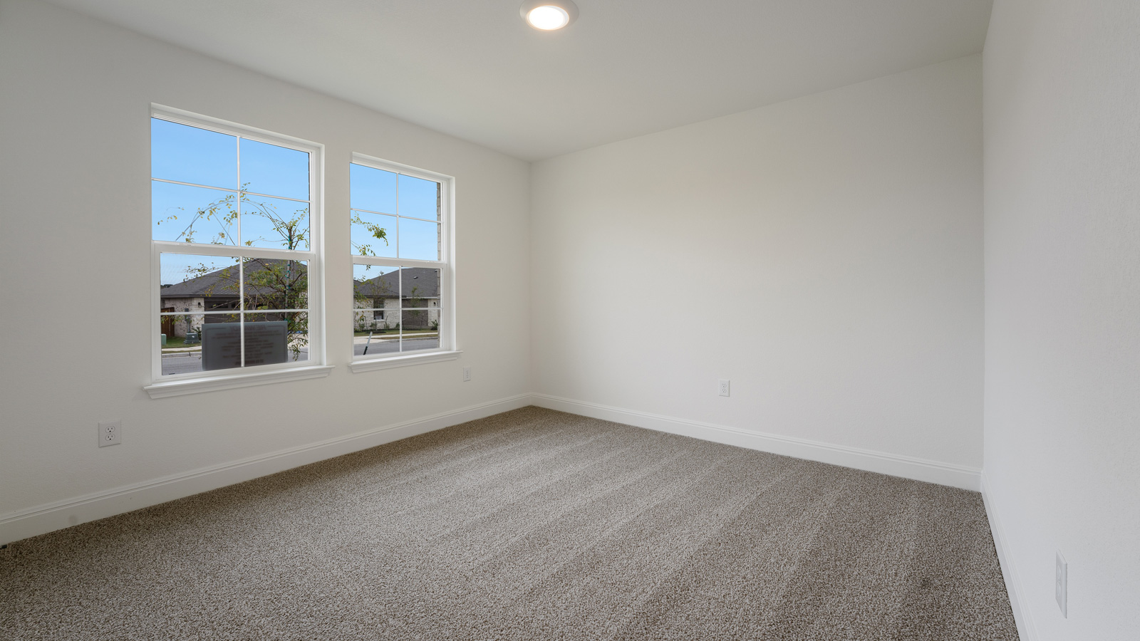 Bedroom 2 with carpeted flooring and large window.