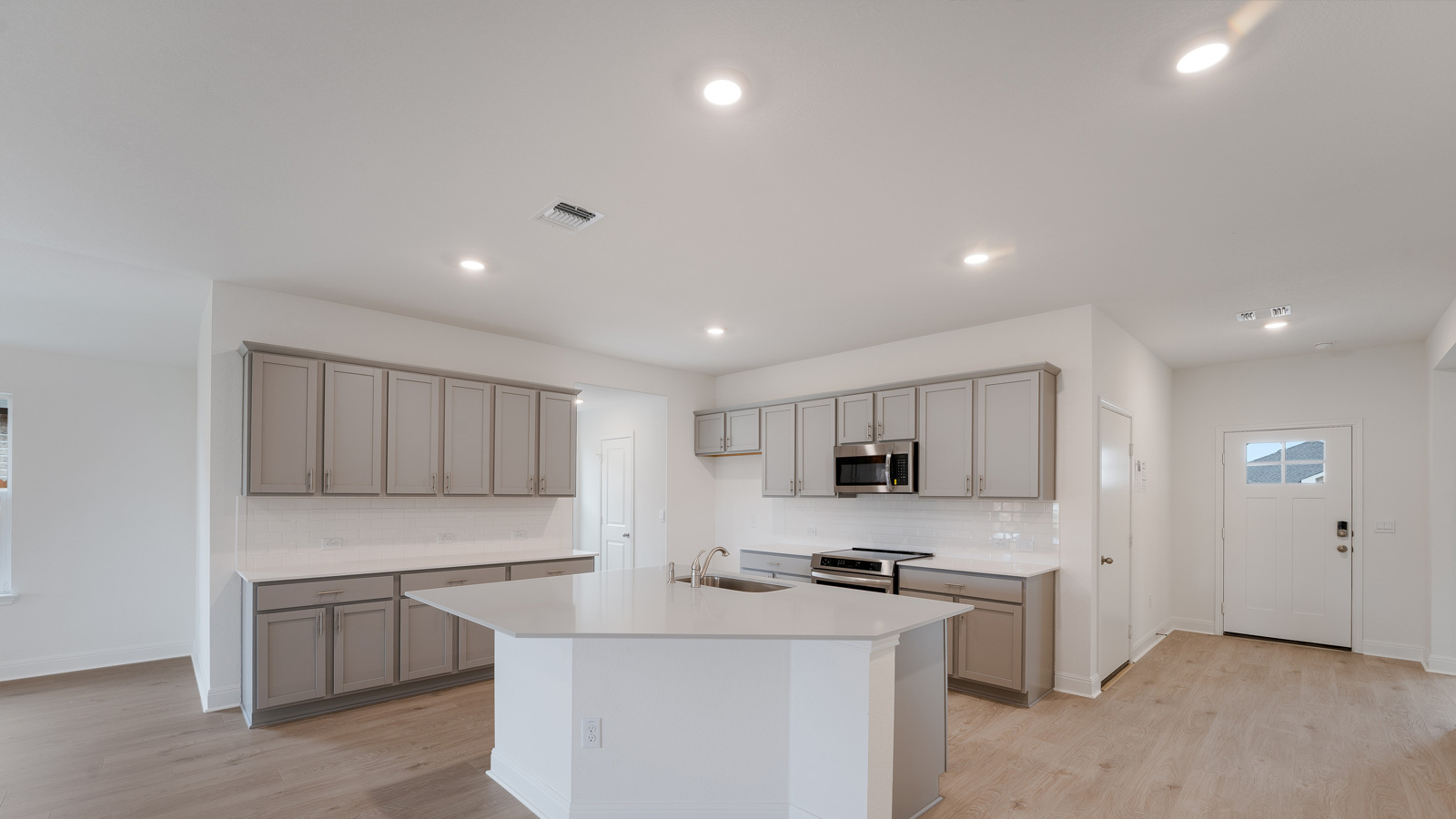 Kitchen features quartz countertop and stainless steel appliances.