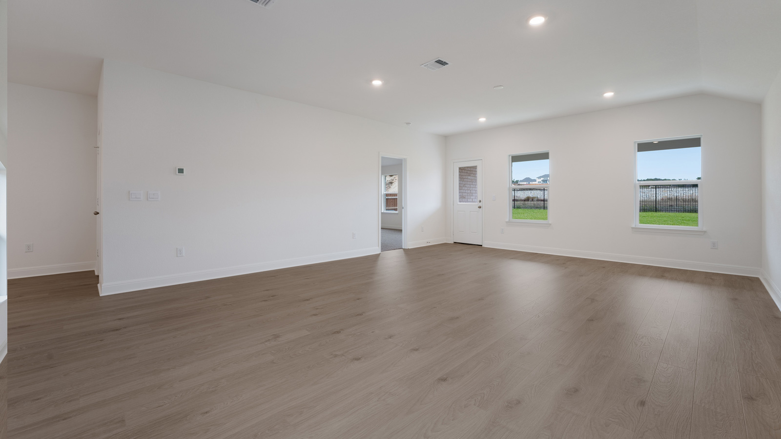 Vast living area with laminated wood flooring.