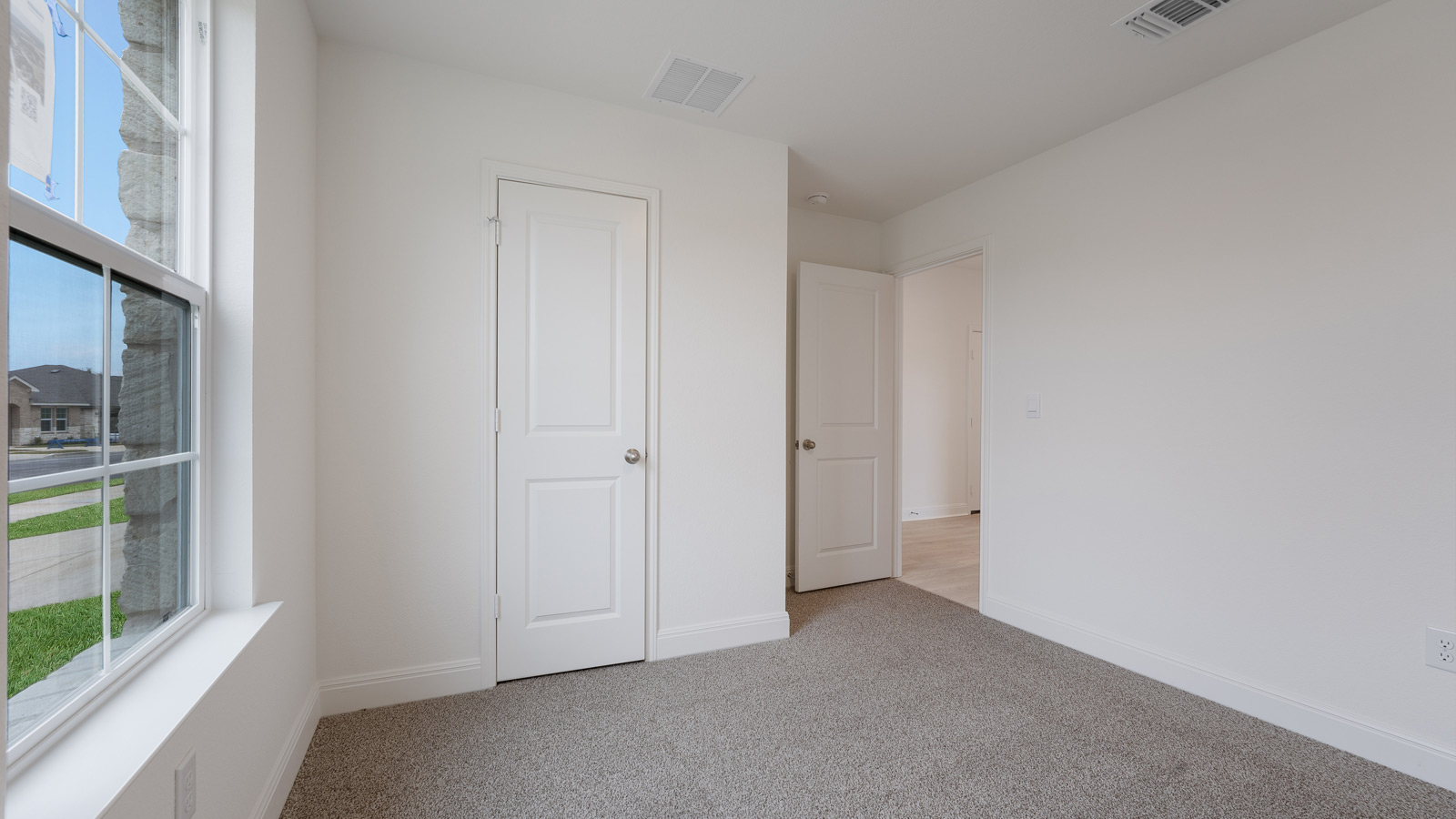 Bedroom 2 with carpeted floors and a storage closet.