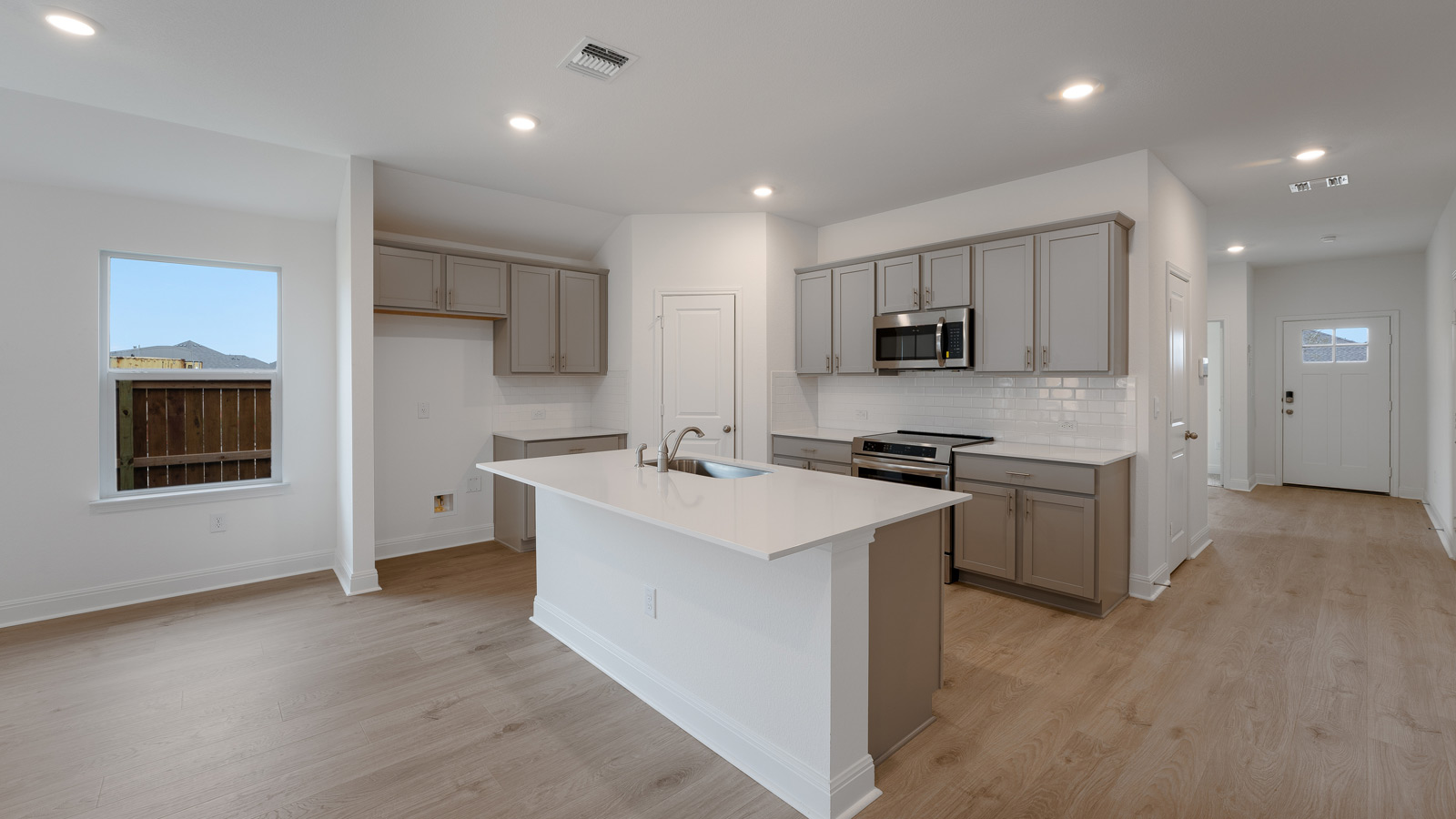 Gourmet kitchen with stainless steel appliances and quartz countertops.