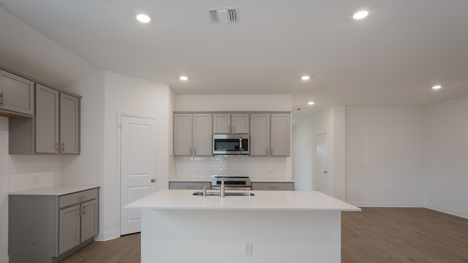 Gourmet kitchen with stainless steel appliances and quartz countertops.