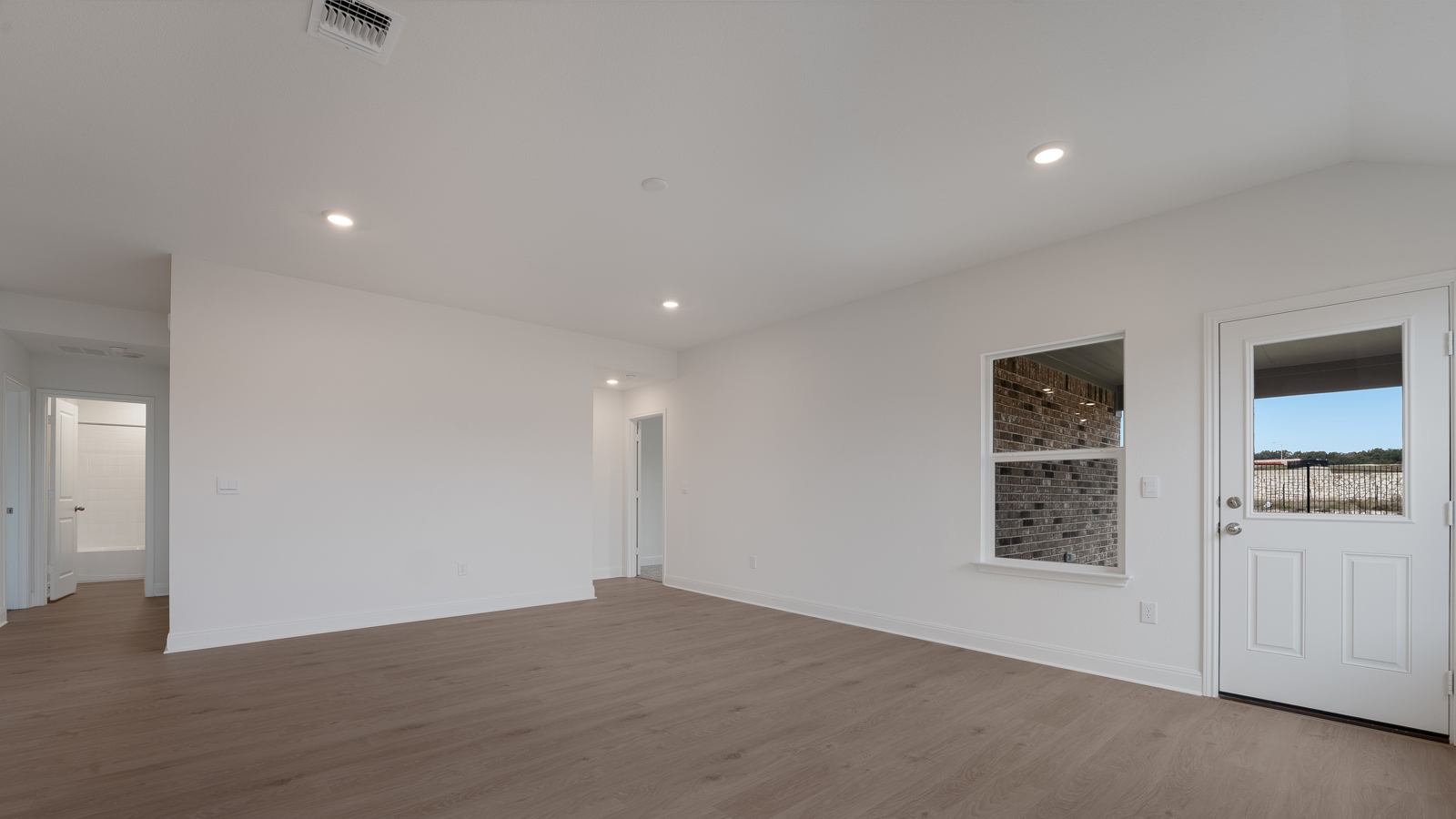Open living area with laminated wood flooring.